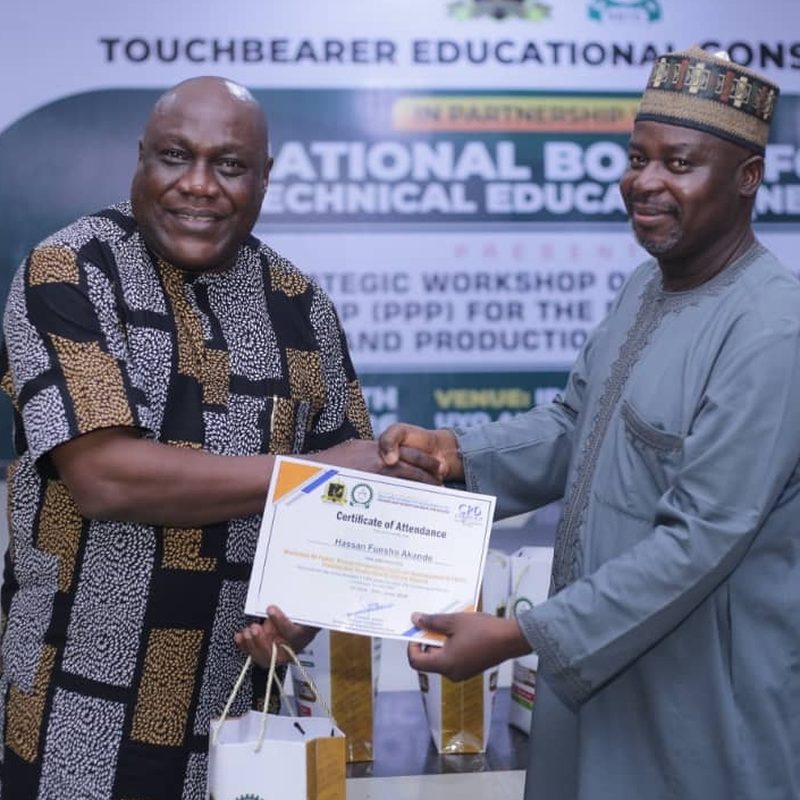 Dr. Godwin Sunday Udom presenting a Certificate of Attendance at the TVET workshop